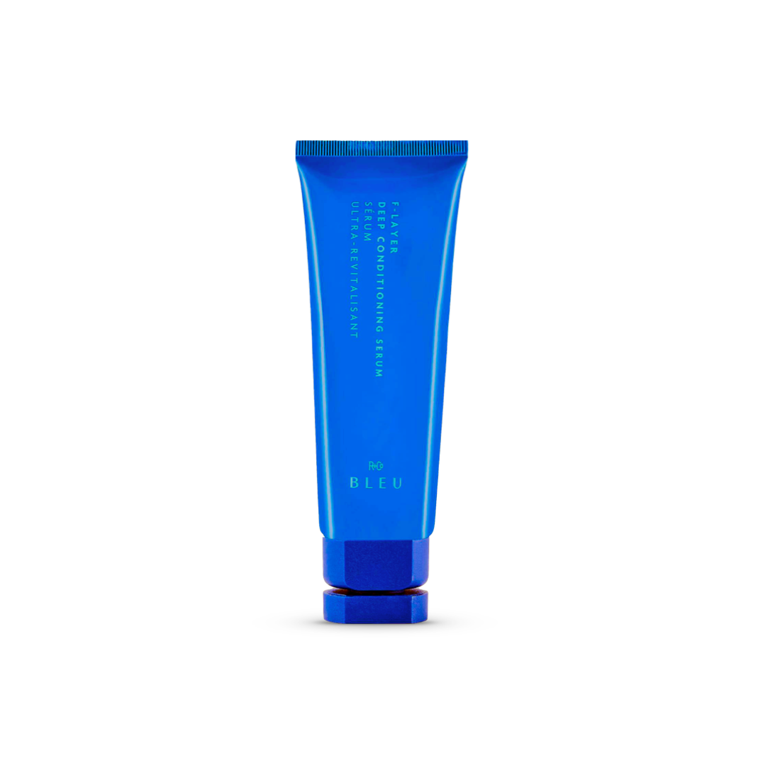 R+Co BLEU F-Layer Deep Conditioning Serum in a vibrant blue tube with a bold blue cap, a restorative leave-in treatment designed to maintain moisture and add shine.