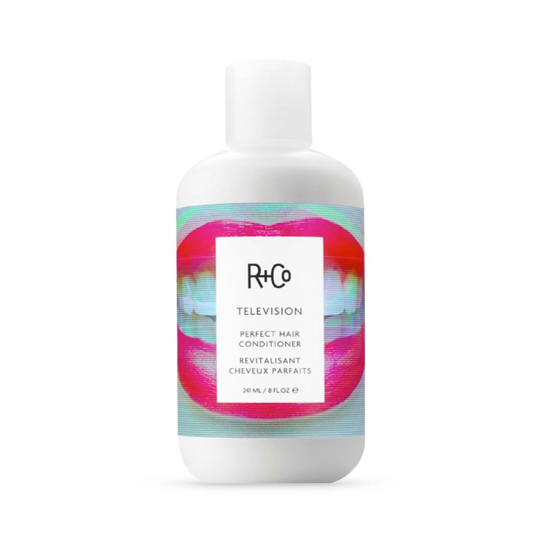 A white bottle of R+Co Television Perfect Hair Conditioner, 241ml/8fl.oz, with a vibrant, holographic label. The design pops with pink and teal waves, indicating the conditioner's promise to deliver perfect body, shine, and smoothness to hair.