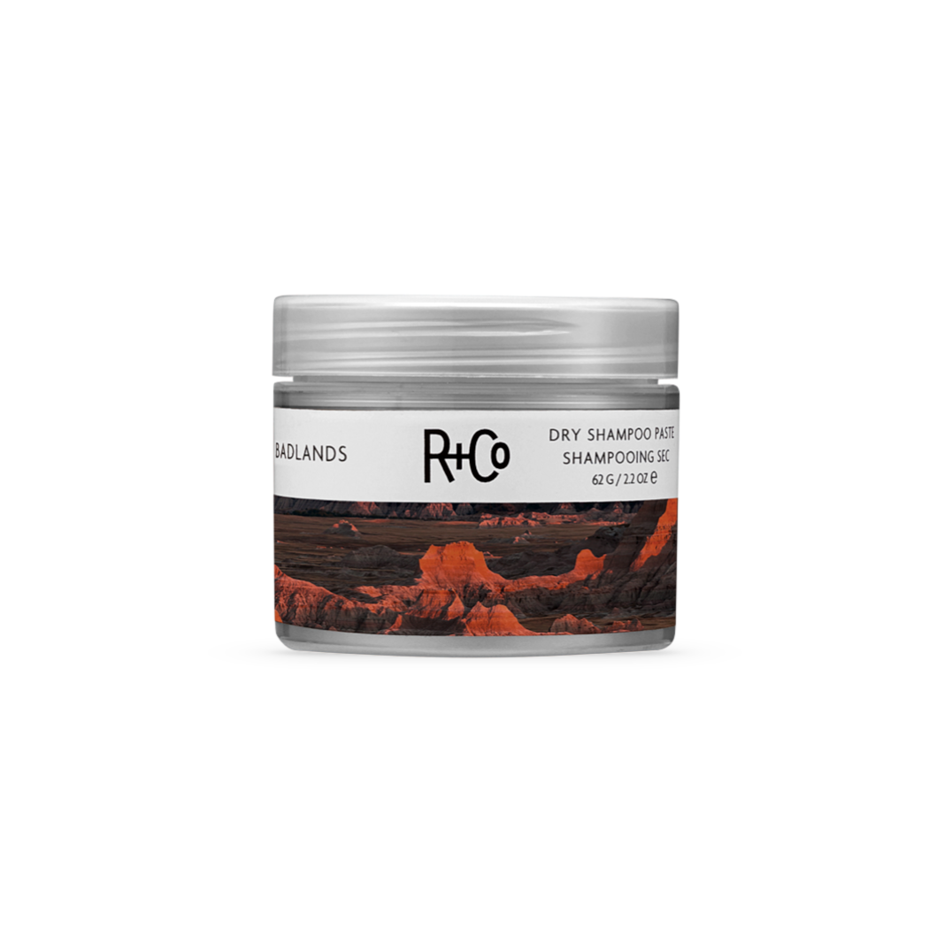 R+Co Badlands Dry Shampoo Paste, 2.2 oz jar, for texture and volume, with a desert landscape design.