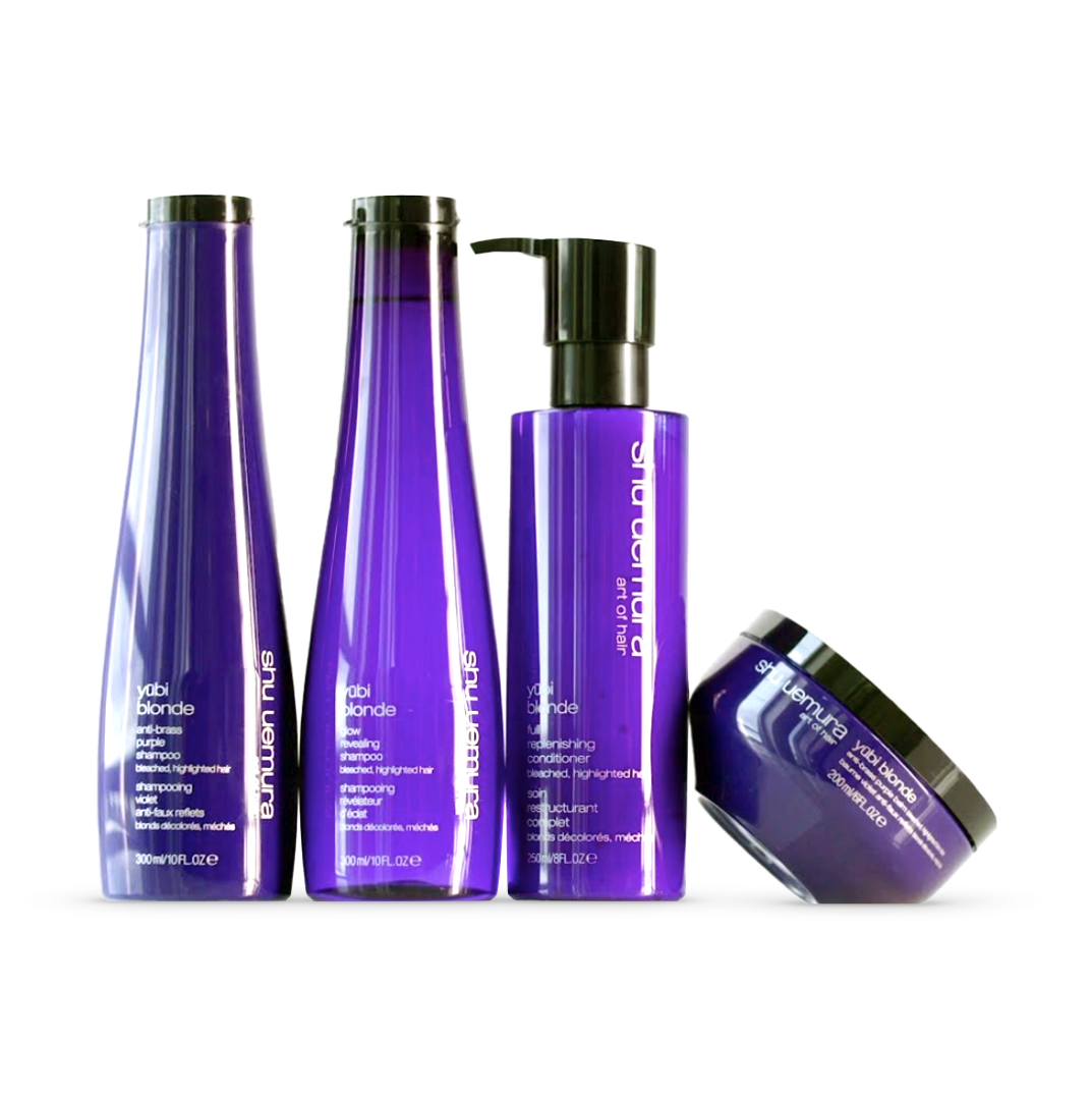 The Shu Uemura Yūbi Blonde product line, featuring sleek bottles and a tub with vibrant purple packaging, symbolizing the line&#39;s specialty in enhancing and caring for blonde and lightened hair. The collection includes the Anti-Brass Purple Shampoo, Full Replenishing Conditioner, and other nourishing hair treatments.